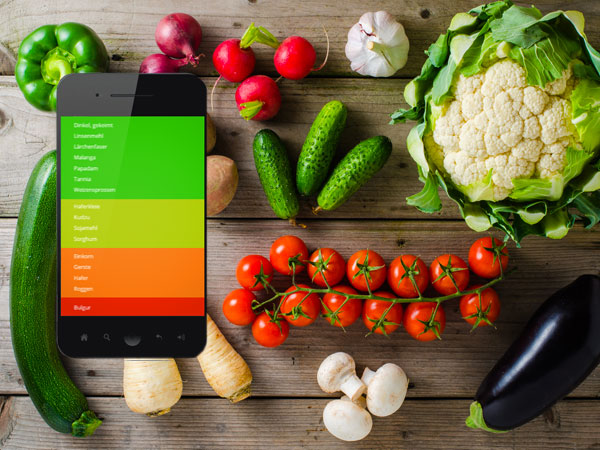 Foodfibel App inmitten von Gemüse auf einem Holztisch: Paprika, Tomate, Aubergine, Pilze, Gurken u.a.. Foto: Mixed vegetables on wooden table, © Leszek Czerwonka, Fotolia #104777454